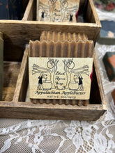 Load image into Gallery viewer, Crinkle cut brownish soap with a black and white label that says Black Apron Soap and Appalachian Applebutter on a lace background.
